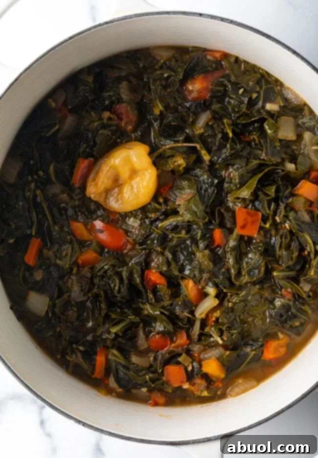 Top down view Jamaican stewed collard greens in a white pot.