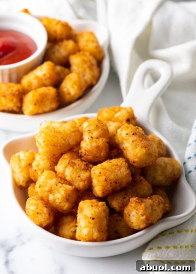 Bowl of perfectly crispy air fryer frozen tater tots, golden brown and ready to eat.