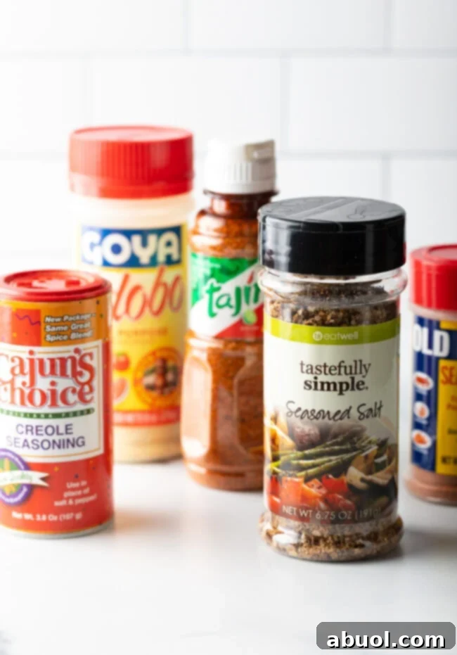 Bottles of various spice blends, including Old Bay, Adobo, and Tajin, suitable for seasoning tater tots.