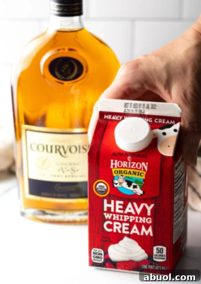 Essential ingredients: a container of heavy whipping cream and a bottle of cognac, ready for sauce preparation.