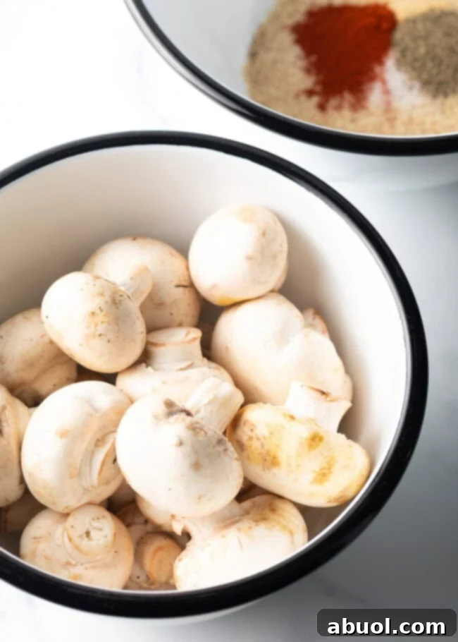 Raw button mushrooms in a bowl.