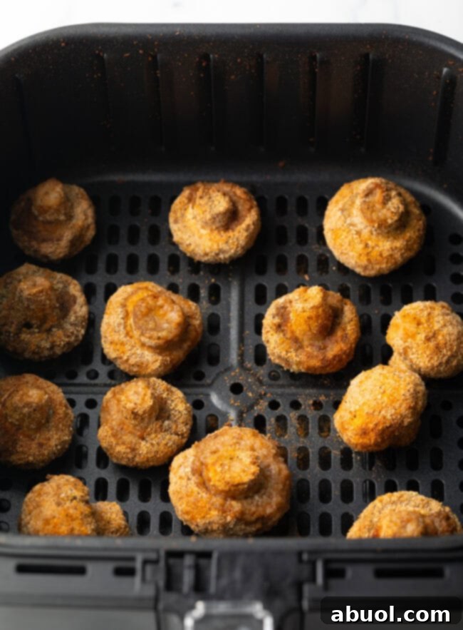 Fried mushrooms in air fryer basket.