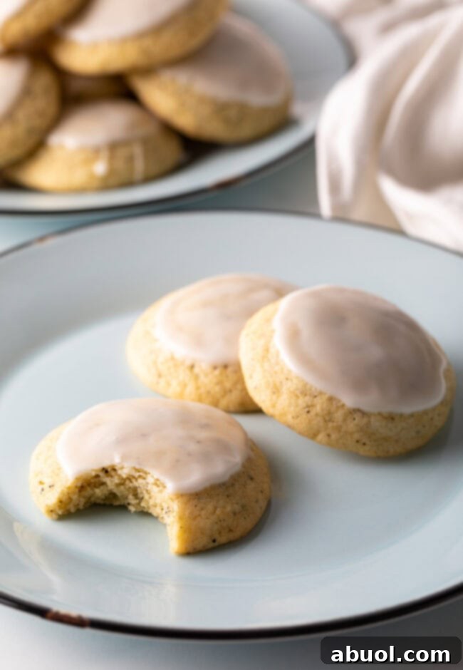 Three Earl Grey cookies on a plate, one with a bite taken out, showing the soft interior.