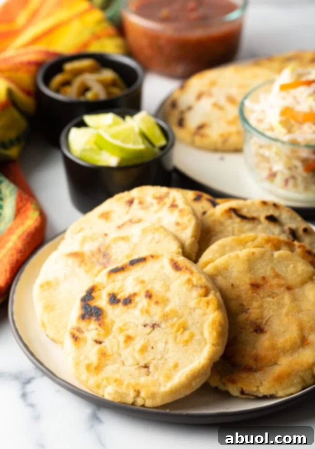 Delicious, thick corn pupusas arranged neatly on a plate, ready to be served.