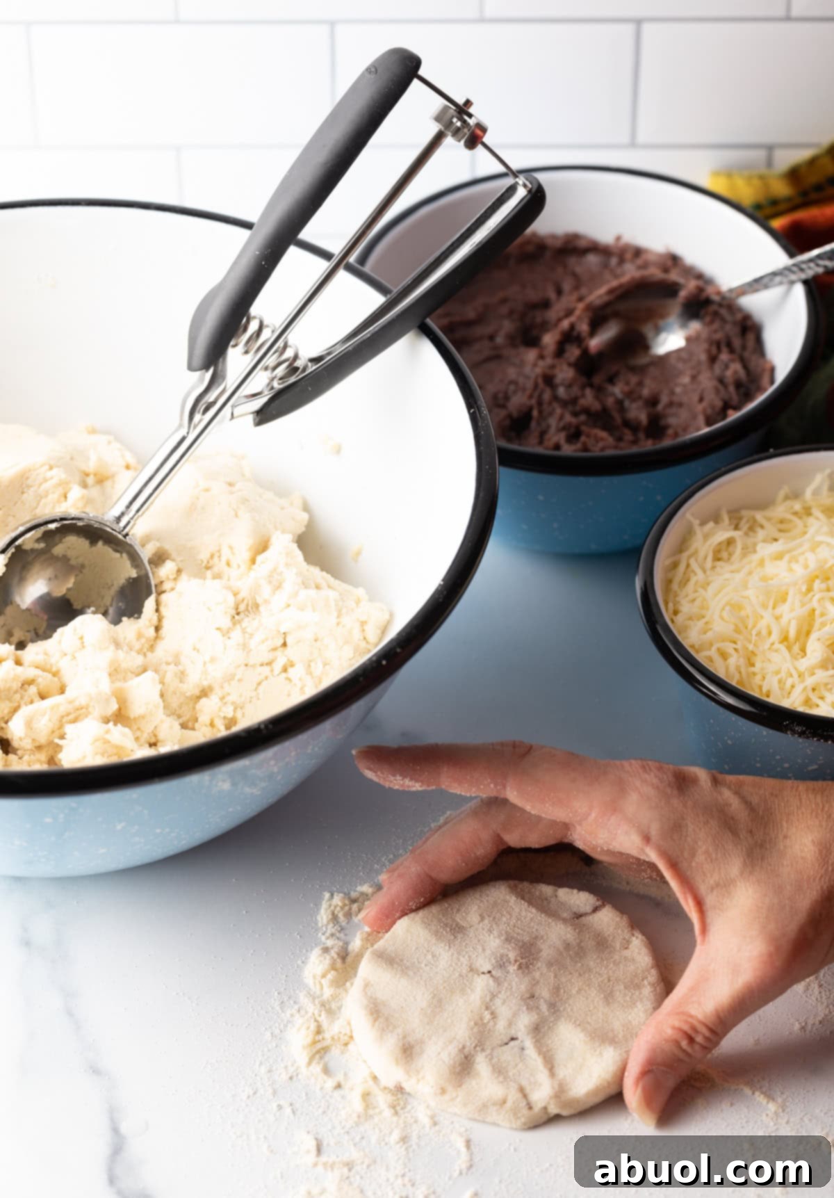A hand proudly showcasing the perfectly flattened and sealed pupusa disk, ready for cooking.
