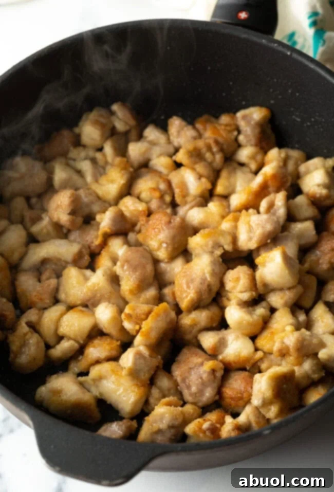 Sauteed cornstarch breaded chicken pieces in a skillet.