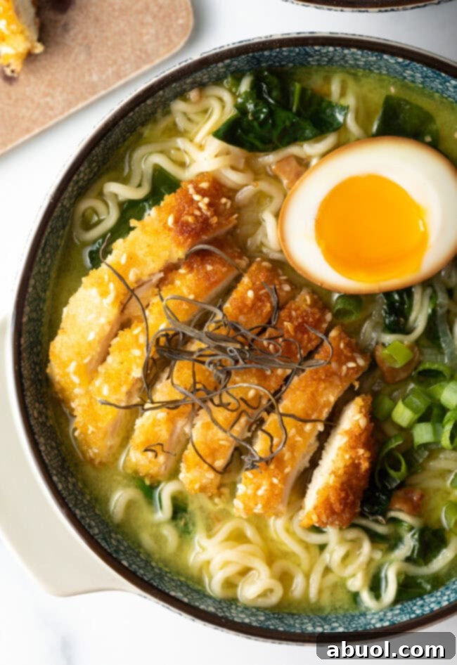 Close-up view of a beautifully arranged bowl of Chicken Katsu Ramen, showcasing crispy chicken, tender noodles, and vibrant toppings.