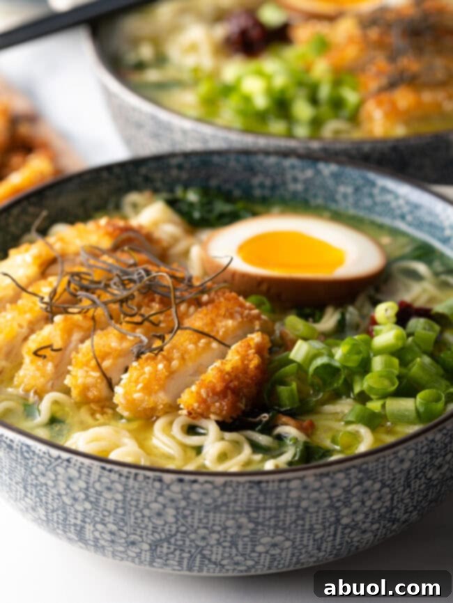 Side view of two generously loaded katsu chicken ramen bowls, showcasing abundant toppings and rich broth.