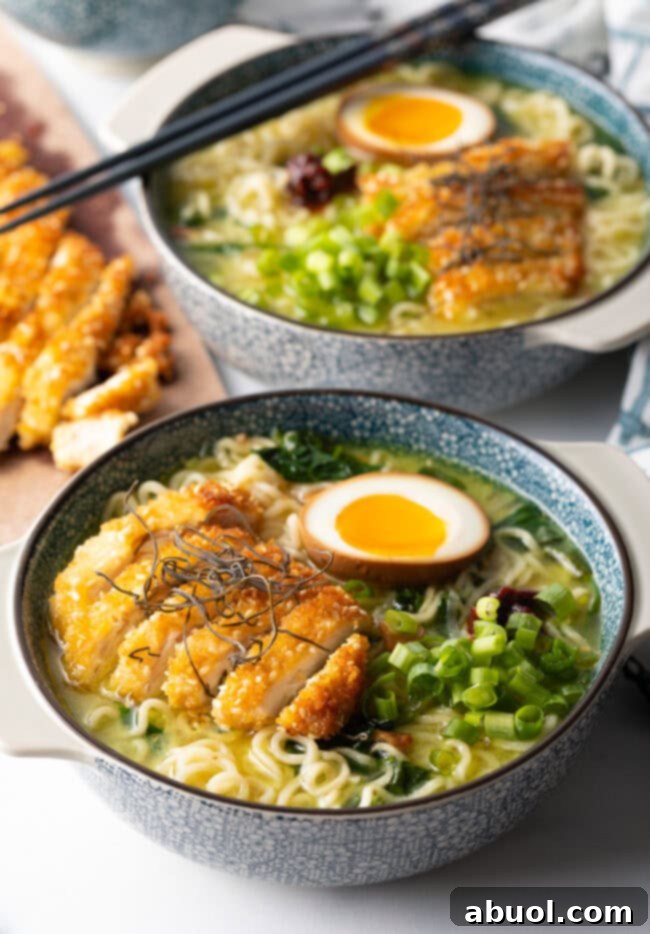 Two bowls of ramen noodle soup, each generously topped with perfectly crispy fried chicken cutlets and an assortment of fresh garnishes.