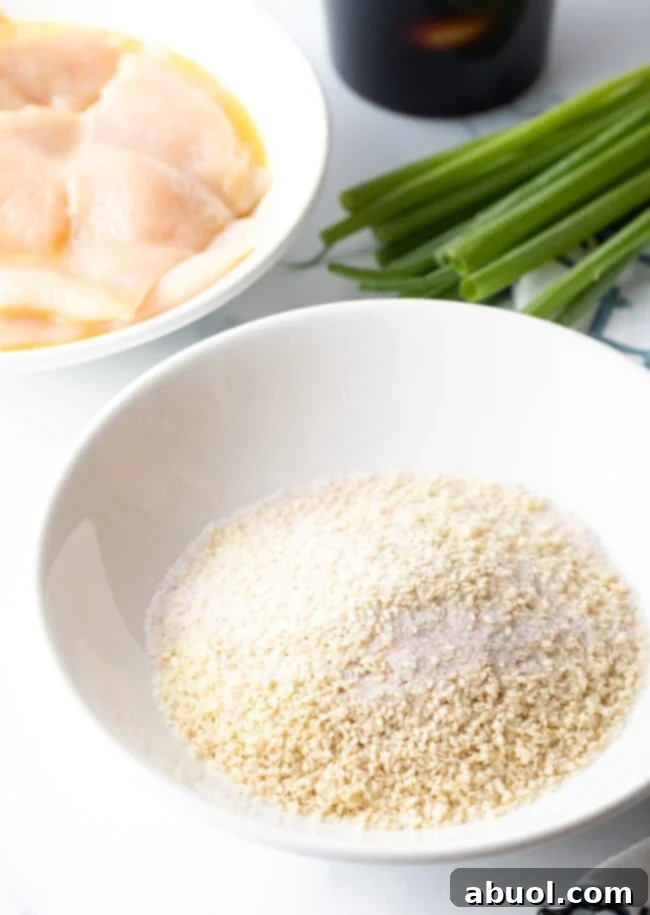 A white bowl filled with a mixture of panko breadcrumbs, sesame seeds, and salt, ready for breading.