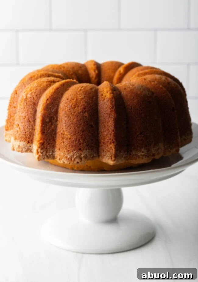 A freshly baked sweet potato pound cake cooling beautifully on a cake stand, ready for its final presentation.
