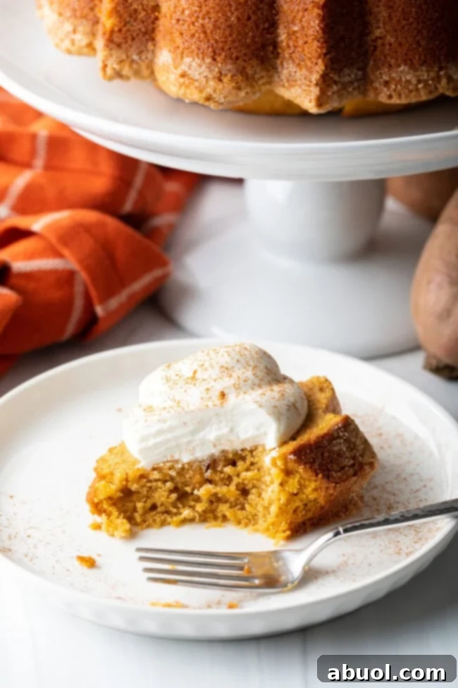 A final close-up shot of a slice of sweet potato pound cake on a white plate, with a bite taken out, highlighting its fluffy texture.