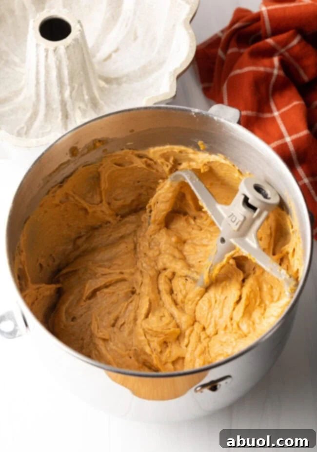 Smooth, blended sweet potato cake batter in a mixing bowl with a paddle attachment, ready for baking.