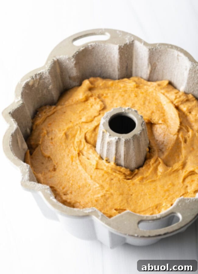 Sweet potato cake batter evenly distributed in a prepared Bundt pan, ready for baking.
