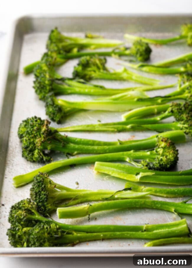 Roasted baby broccoli on a baking sheet.