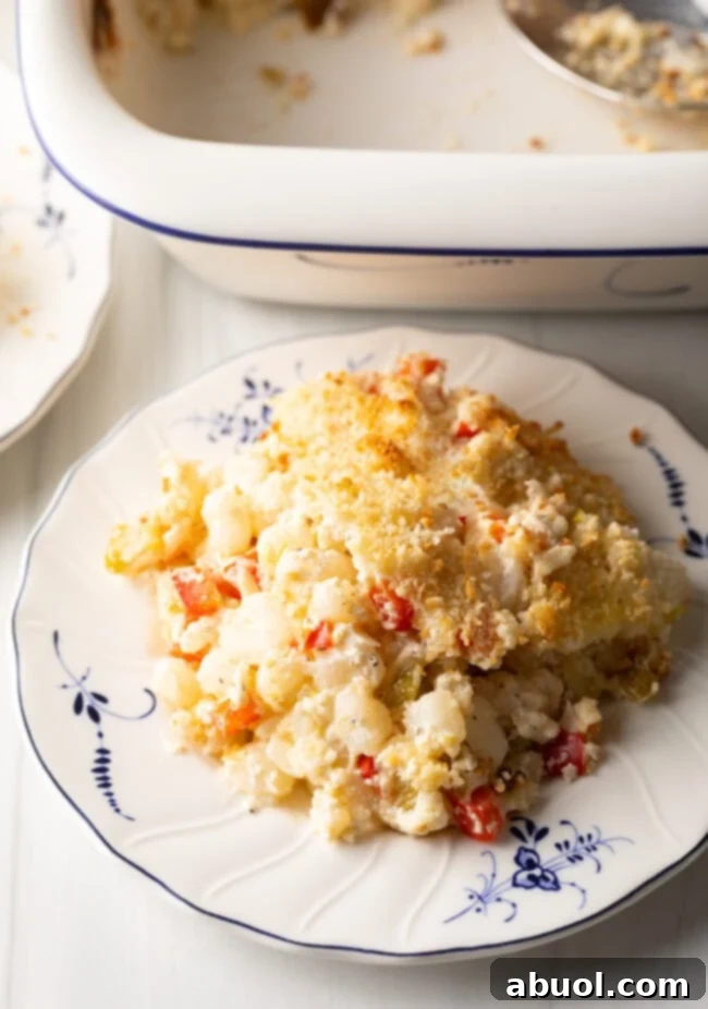 Golden Cheesy Hominy Bake 2 Portion of cheesy hominy casserole on a plate.