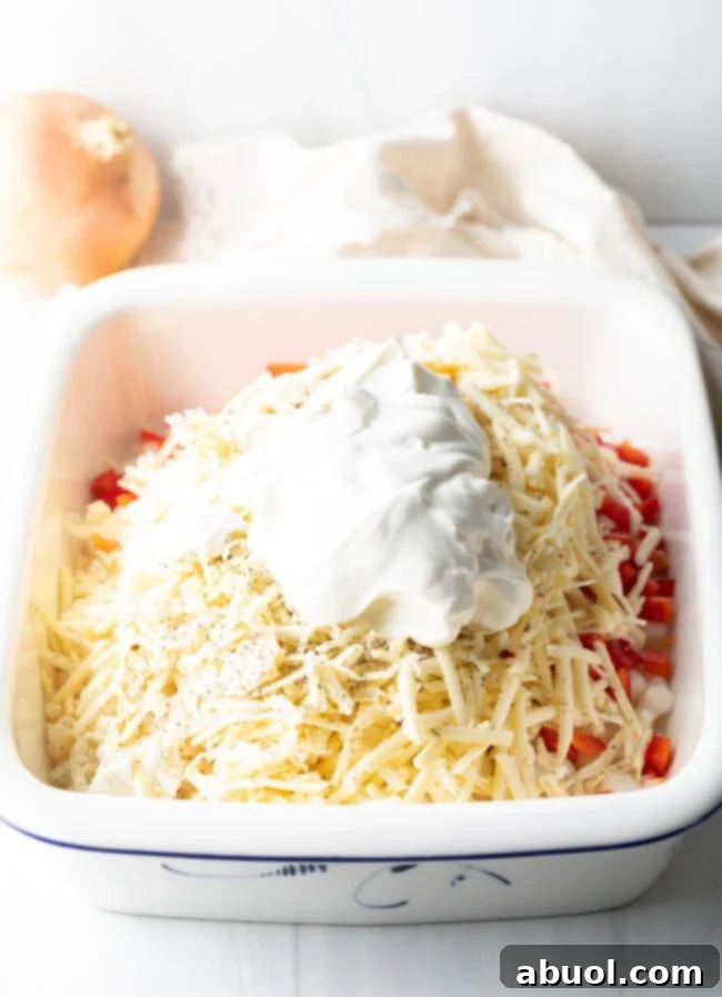 Golden Cheesy Hominy Bake 7 Sour cream and shredded cheese added to the baking dish.