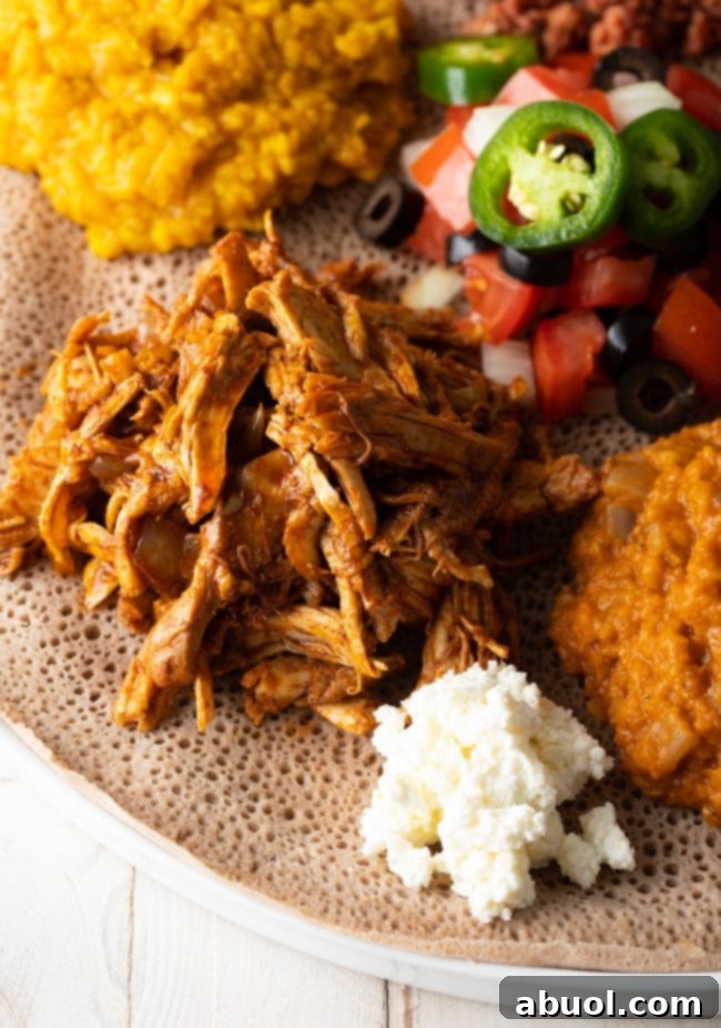 Injera topped generously with a variety of colorful Ethiopian dishes, showcasing its fundamental role as an edible serving base.