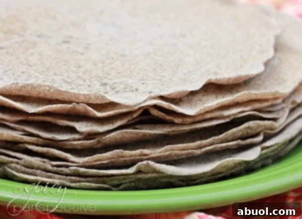 Freshly cooked Injera bread stacked neatly on a plate, indicating its soft, pliable texture and readiness for serving.