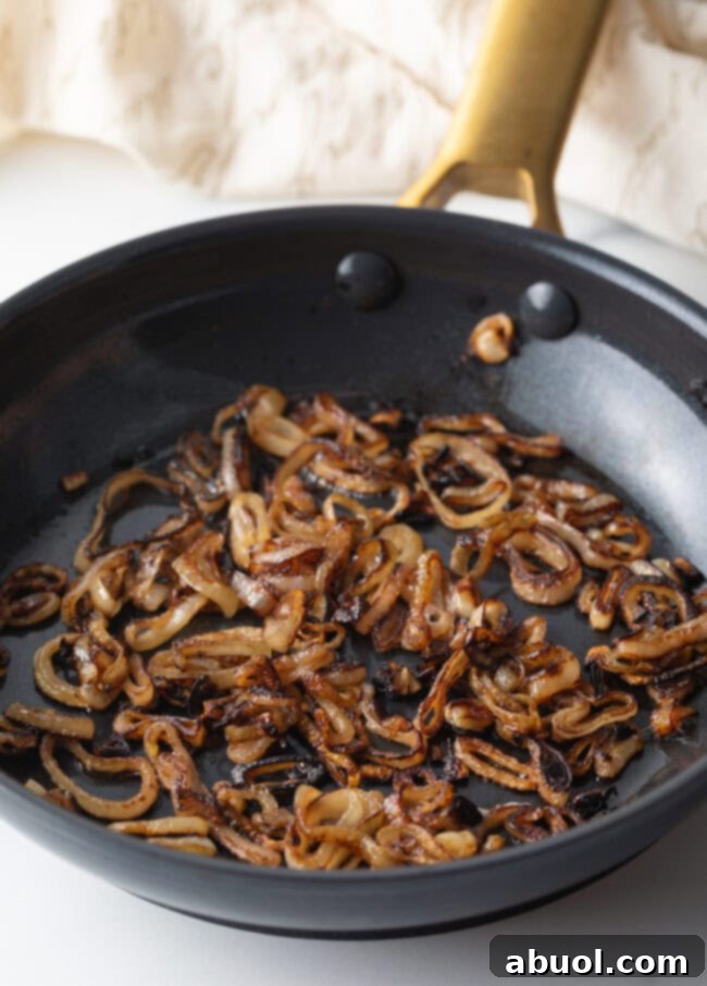 Sauteeing sliced shallots in a skillet until browned.