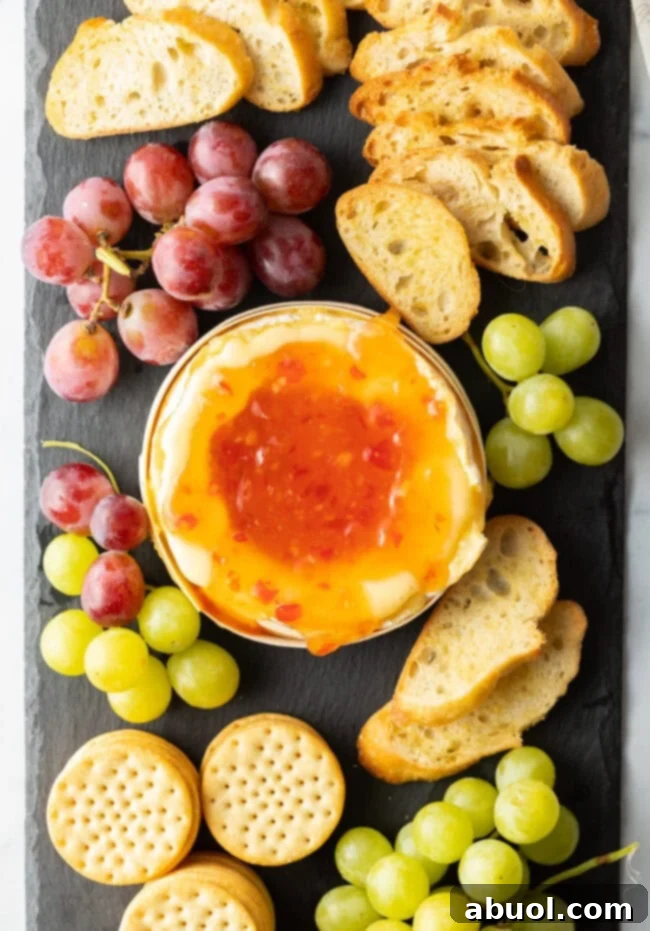 Top down view, sweet chili sauce added to the baked cheese surrounded by dippers.