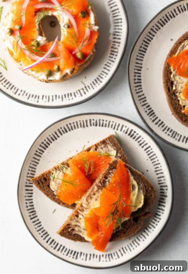 A top-down perspective of an exquisitely arranged spread featuring various final dishes, all prominently showcasing perfectly salt-cured salmon (gravlax) prepared to perfection.
