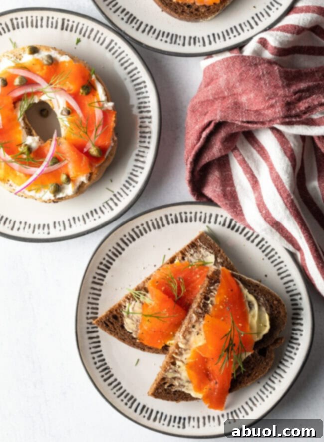 A top-down view of two beautifully composed final dishes, each artfully topped with delicate slices of homemade easy gravlax, ready to be served.