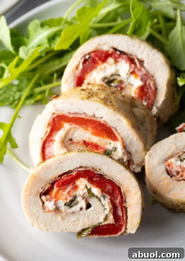 Sliced chicken roulade pieces on a plate with close view of cut section.