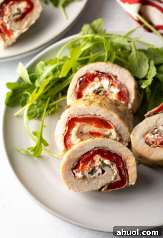 Close up of a plate of sliced chicken roulade with a side of mashed potatoes.