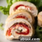 Sliced chicken roulade pieces on a plate with close view of cut section.