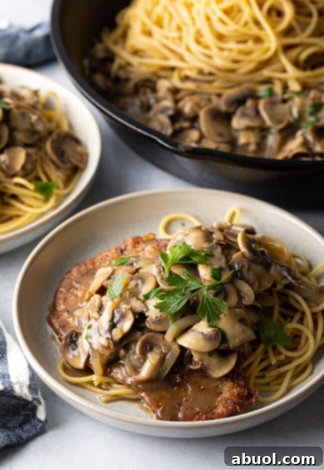 Spaghetti and veal cutlet topped with mushroom sauce and fresh parsley.