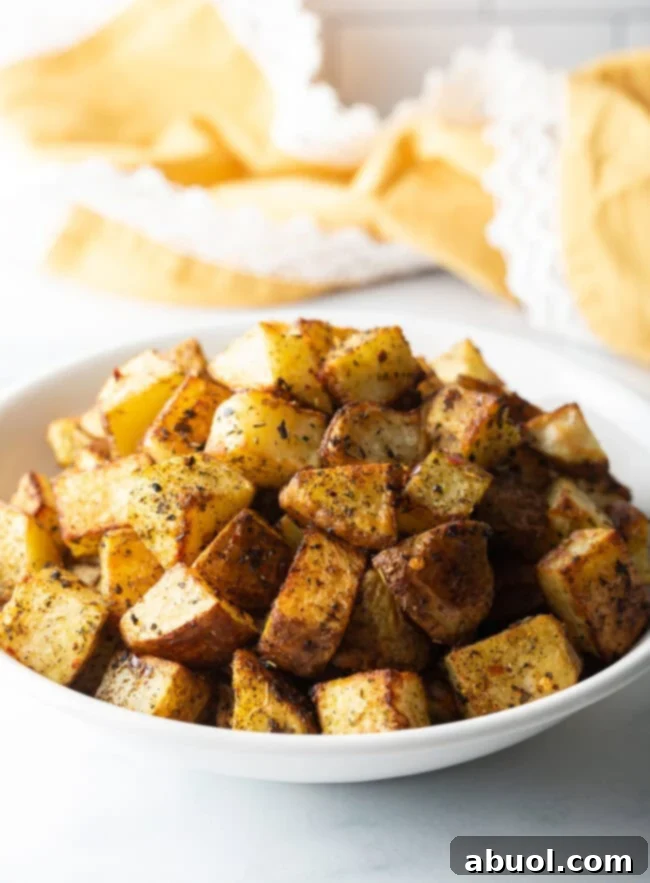 Russet Potato Recipe and Tips -Close view cubed fried potatoes in a white bowl.