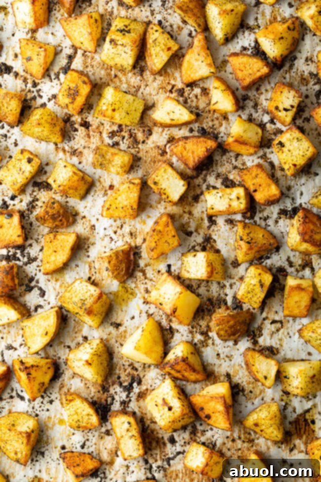 Top down view cubes of roasted russet potatoes on a baking sheet lined with parchment.