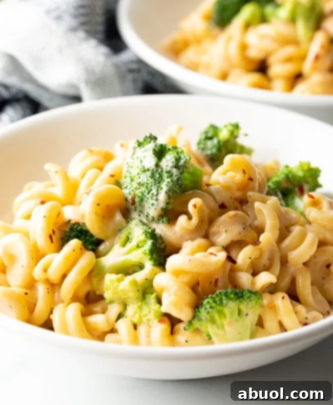 Perfectly Creamy Broccoli Pasta 2 Close view white bowl with creamy cheesy broccoli pasta.