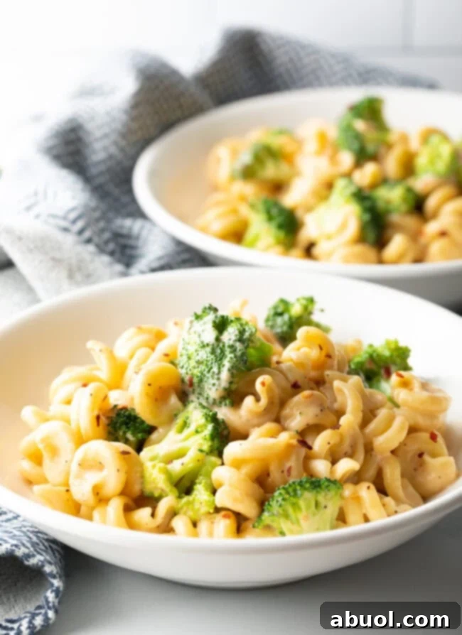 Perfectly Creamy Broccoli Pasta 5 Two bowls of pasta with creamy sauce and broccoli.