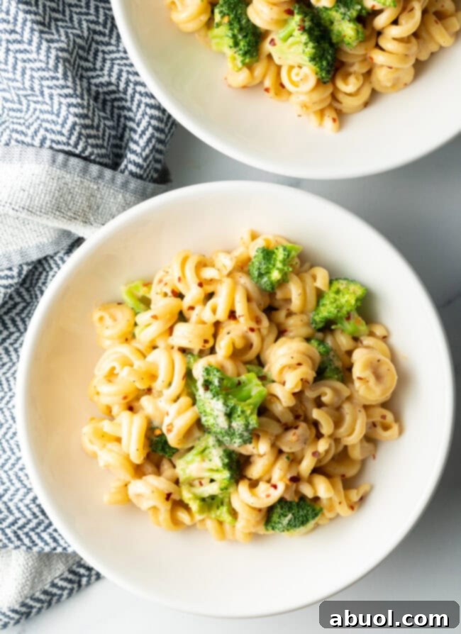 Perfectly Creamy Broccoli Pasta 9 Two bowls top down pasta with boiled broccoli and cheese sauce.