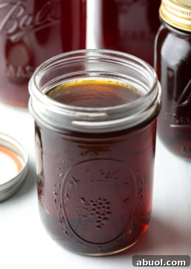 Close up view of beef consomme in a glass jar.
