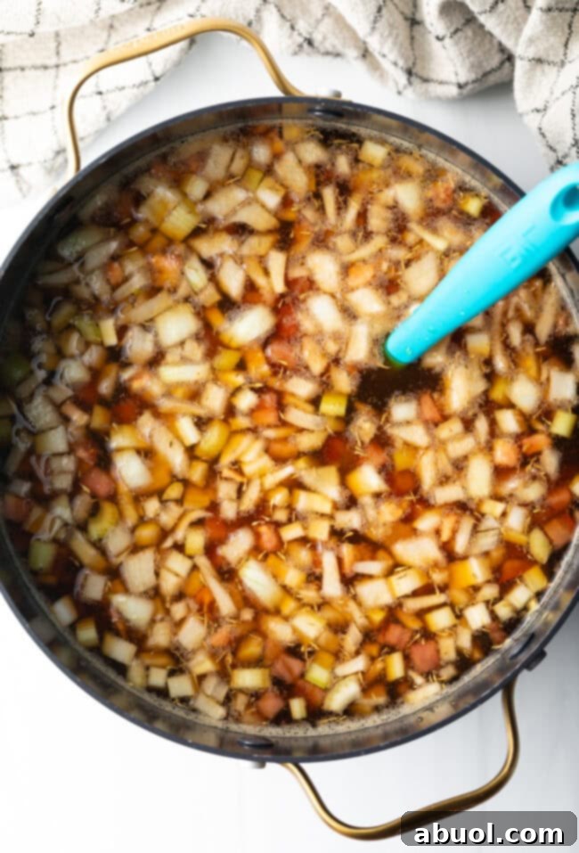 Top down view of consomme ingredients boiling in a pot.
