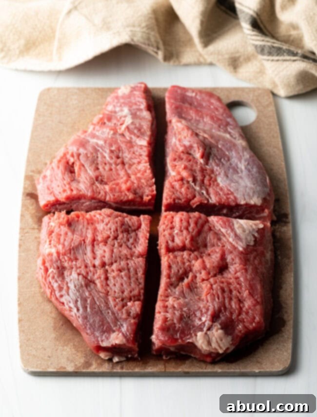 Savory Spiced Beef Shawarma 6 Large piece of flank steak cut into 4 quarters, on a cutting board.