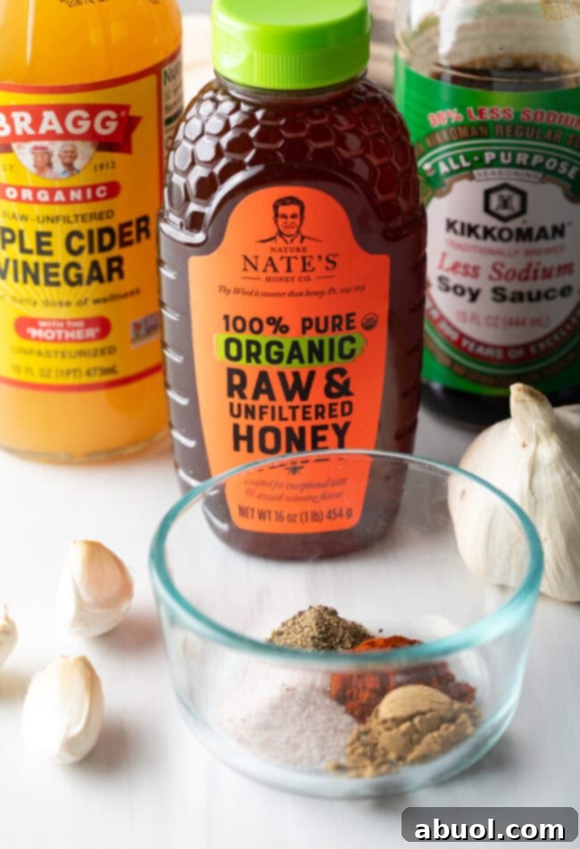 A vibrant flat lay photo showcasing all the fresh ingredients needed for Glazed Honey Garlic Pork Tenderloin, including fresh garlic, honey, soy sauce, apple cider vinegar, and various spices.