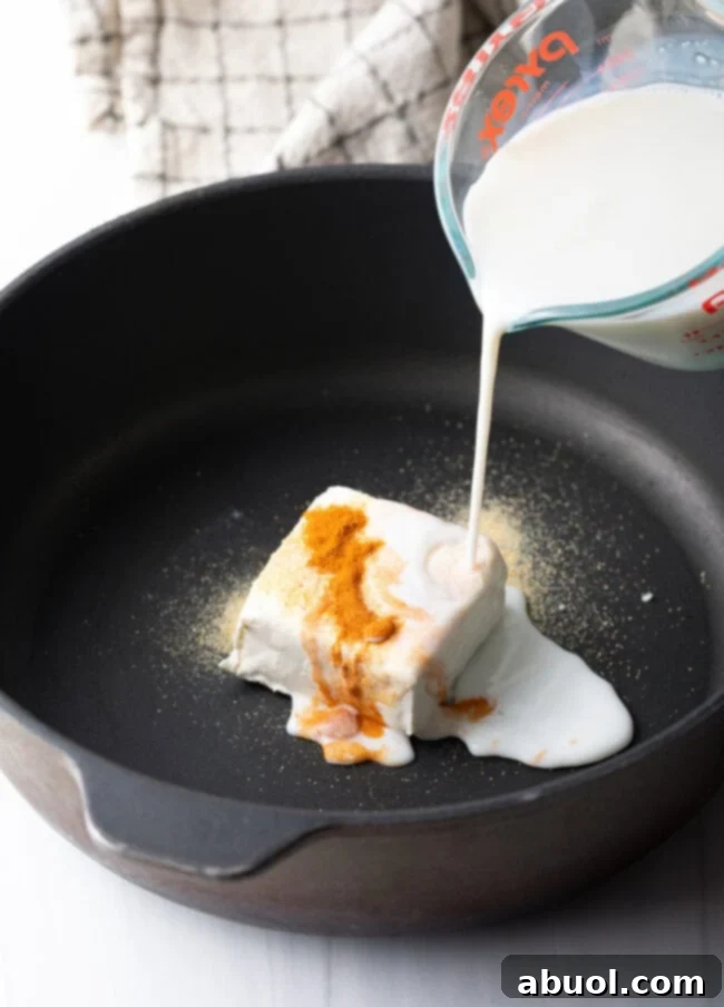 Close-up of freshly shredded sharp cheddar cheese, ideal for melting into a smooth sauce.