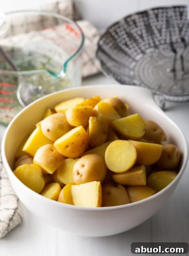 White bowl with boiled halved potatoes.