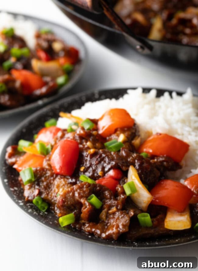 Sweet and Crispy Panda Express Beijing Beef 2 A black bowl filled with crispy Beijing Beef and steamed white rice, showcasing the vibrant colors of the dish.
