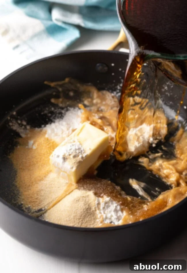 Delicious Homemade Beef Gravy 6 Adding beef stock to cooking pan with flour and butter.