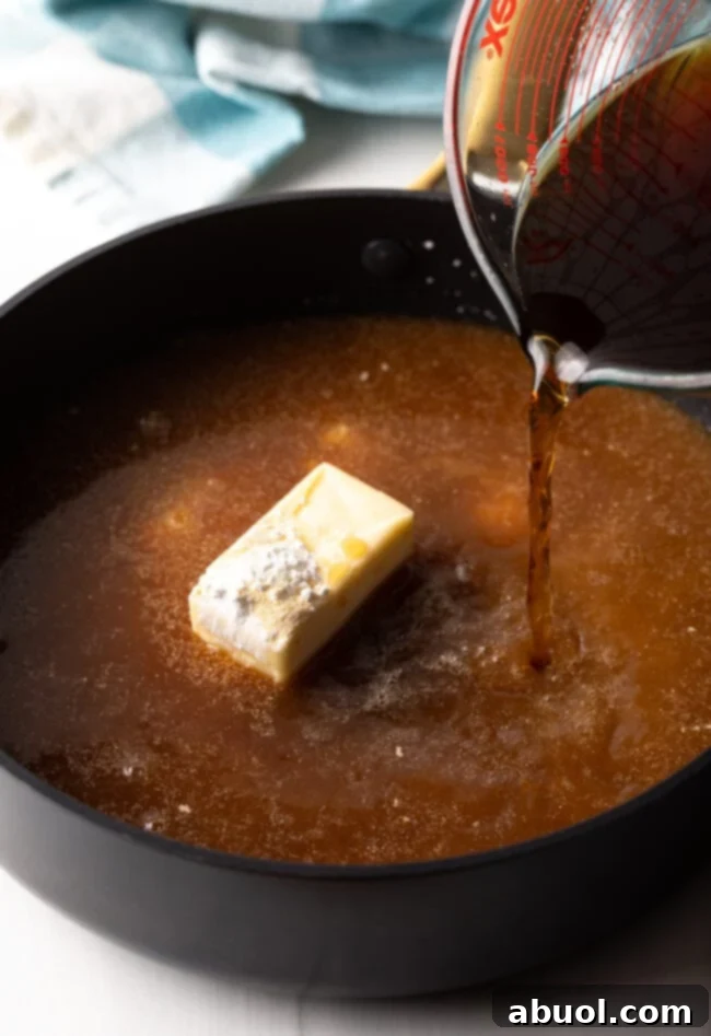 Delicious Homemade Beef Gravy 7 Beef broth being poured into deep skillet, with butter and flour.