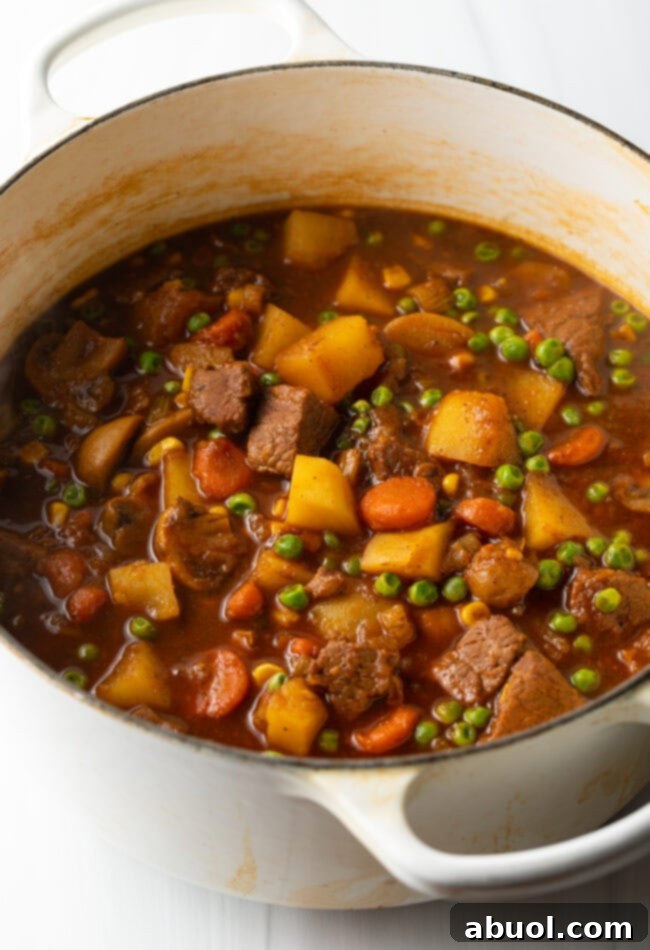 Chopped carrots, celery, onion, mushrooms, and potatoes with chunks of beef in a dutch oven for Irish beef stew