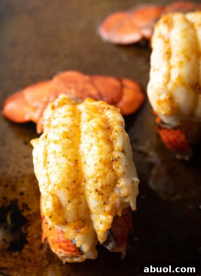 Close view plump cooked lobster tail on a baking sheet.