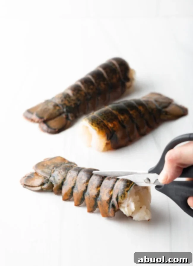 Using kitchen shears to cut the shell in half lengthwise.