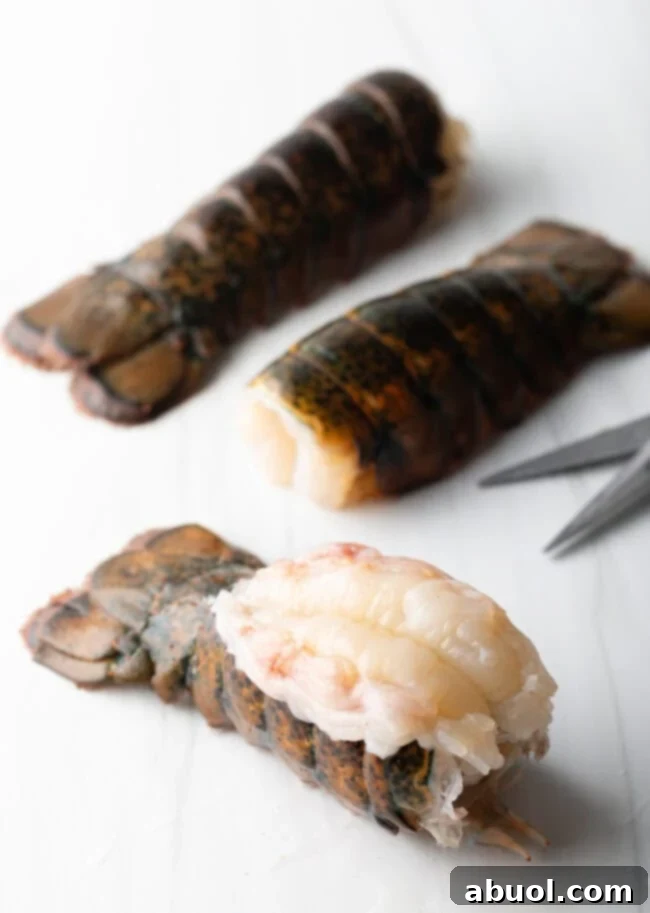 Raw lobster tail with meat exposed, on a white background.