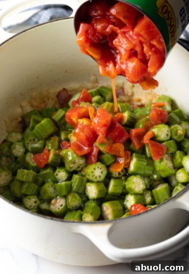 Adding canned diced tomatoes and their juices to the pot with chopped vegetables and bacon, a crucial step for the stew's base.